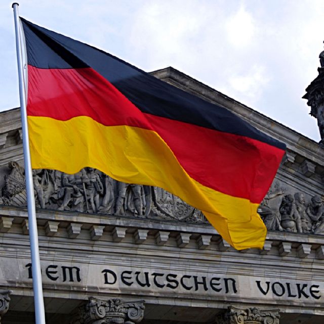 Reichstag mit deutscher Flagge; Rente im Ausland