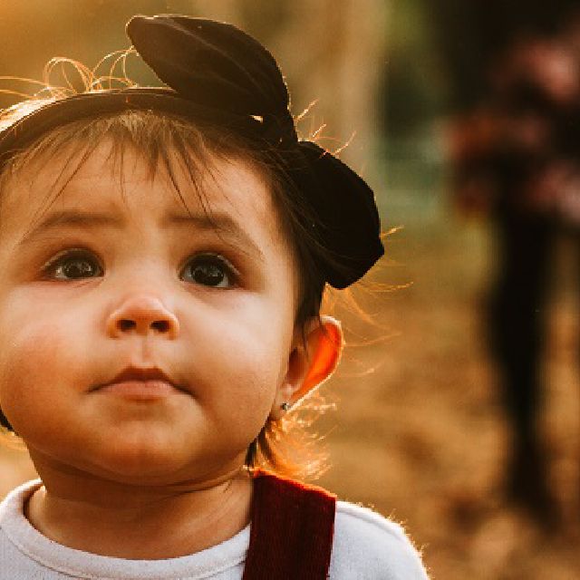 Ein Kleinkind vor unscharfem Hintergrund.