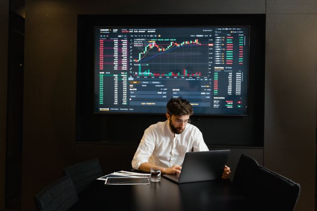 Mann vor Computer-Bildschirm; Prognose: Das erwarten Experten für die Börsenkurse 2024