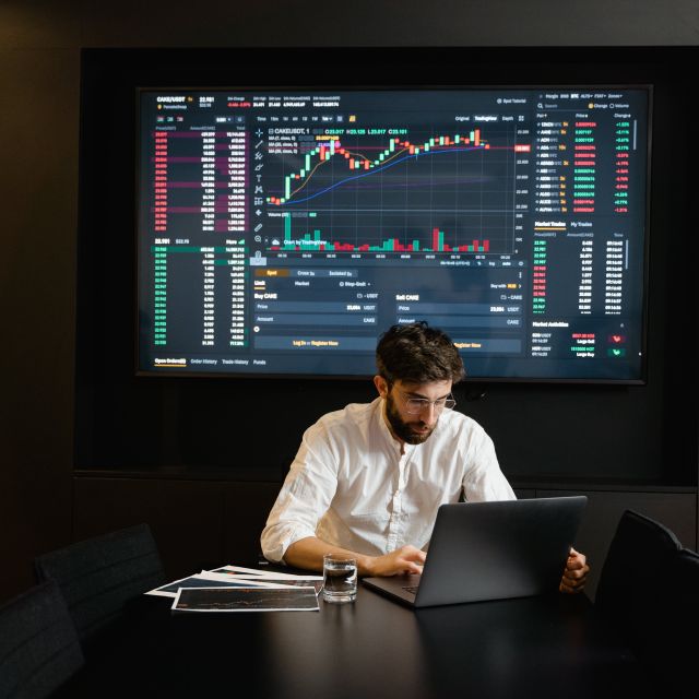 Mann vor Computer-Bildschirm; Prognose: Das erwarten Experten für die Börsenkurse 2024