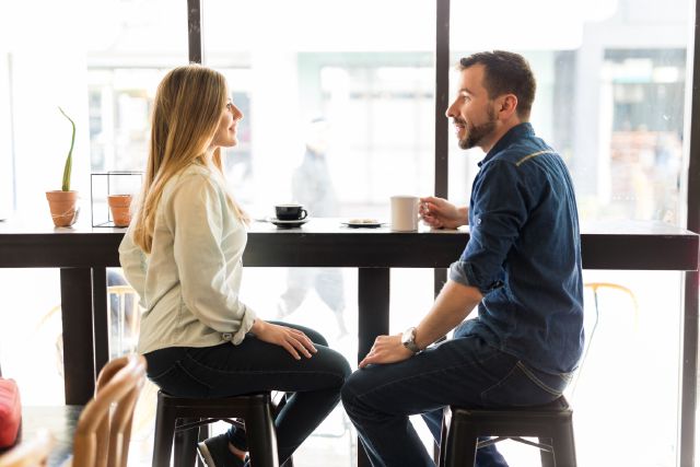 Mann und Frau sitzen fröhlich beim Kaffee trinken; Wie Sie am besten Geld kurzfristig anlegen