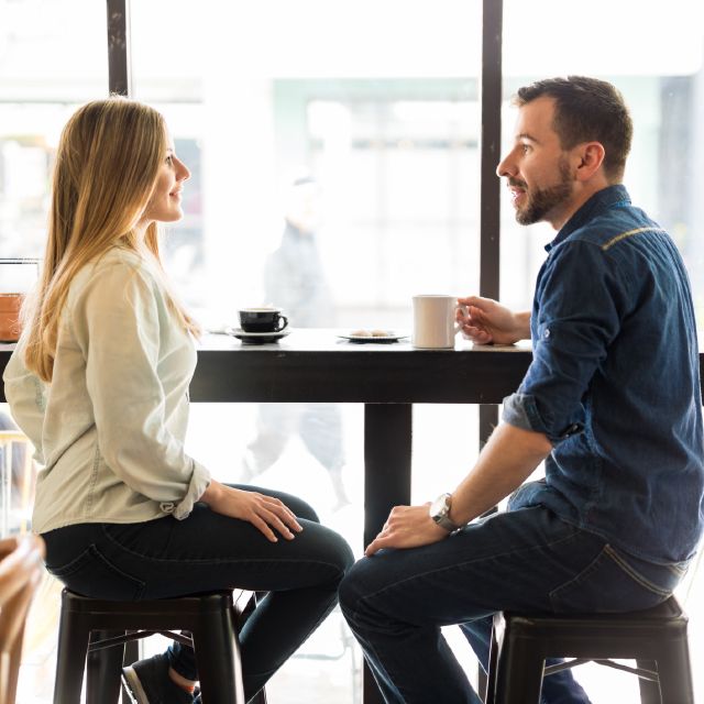 Mann und Frau sitzen fröhlich beim Kaffee trinken; Wie Sie am besten Geld kurzfristig anlegen