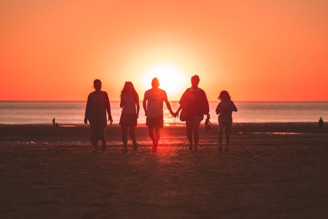 Familie im Sonnenuntergang am Strand; Finanzen & Familie: Optimale Geldanlage für Familien