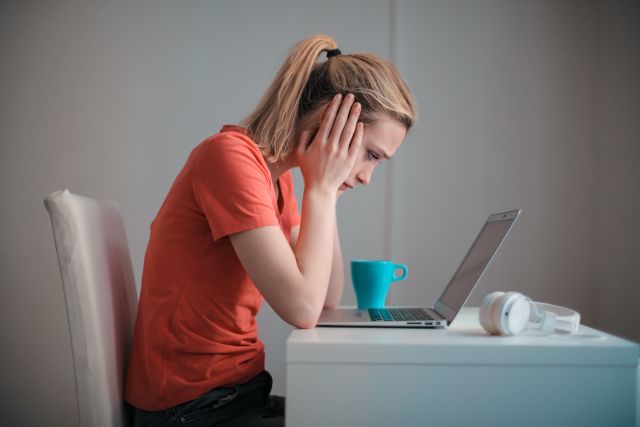 Frau guckt verzweifelt auf ihren Laptop; 7 typische Anlegerfehler beim Investieren