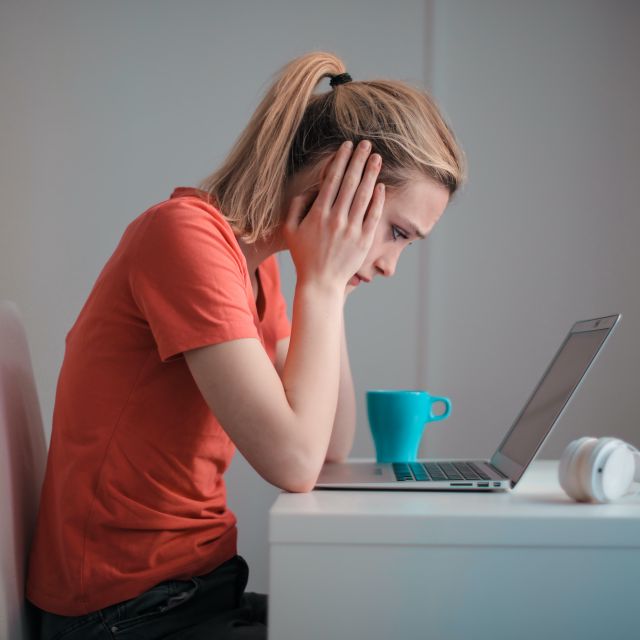 Frau guckt verzweifelt auf ihren Laptop; 7 typische Anlegerfehler beim Investieren