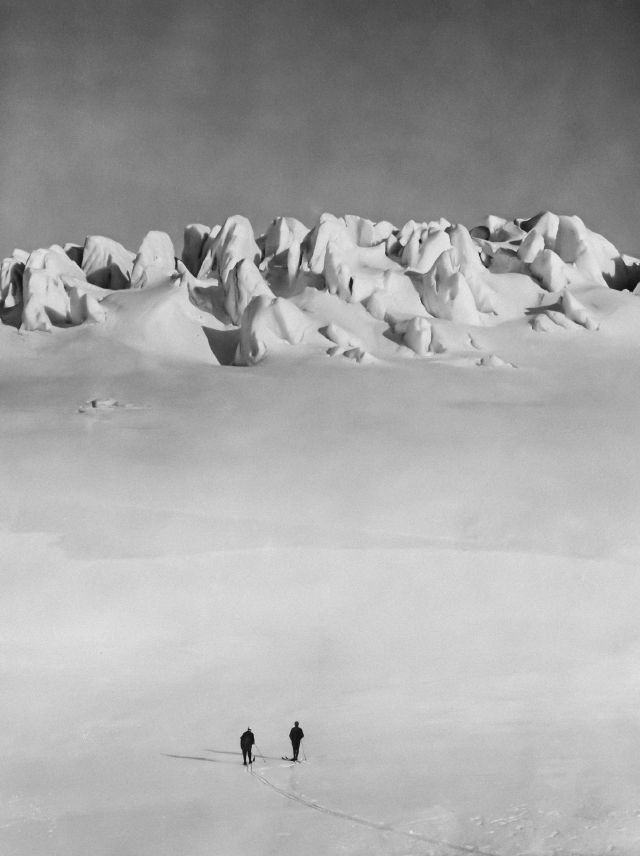 Two people walking towards a mountain