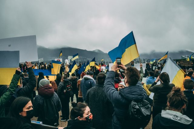 Menschen mit Ukraine-Fahnen; Auswirkungen des Ukraine-Kriegs: Banken, Wirtschaft, Handel, ETFs