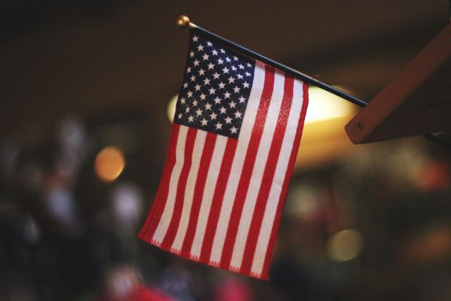 US-Flagge vor unscharfem Hintergrund; Streit um Schulden: Was wäre, wenn die USA zahlungsunfähig sind?